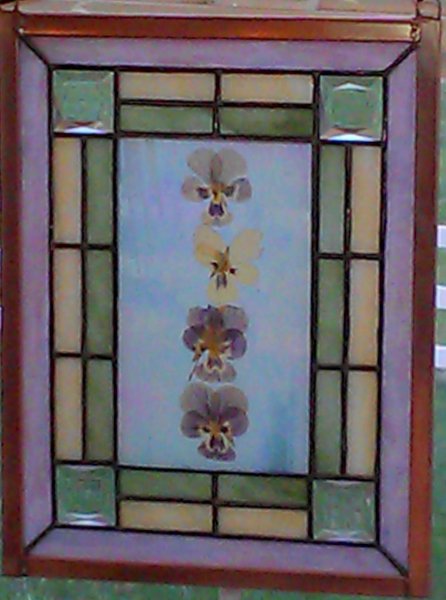 Four real flowers enclosed between to panels