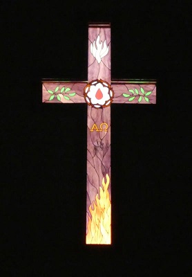 stained glass cross in a dark room